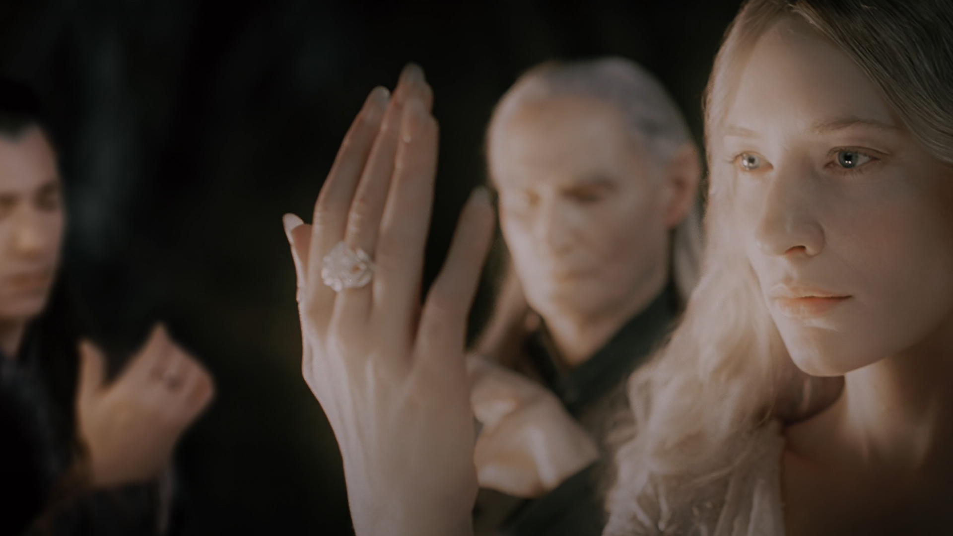 A screenshot from the movie “The Fellowship of the Ring” showing the three elves examining their rings of power