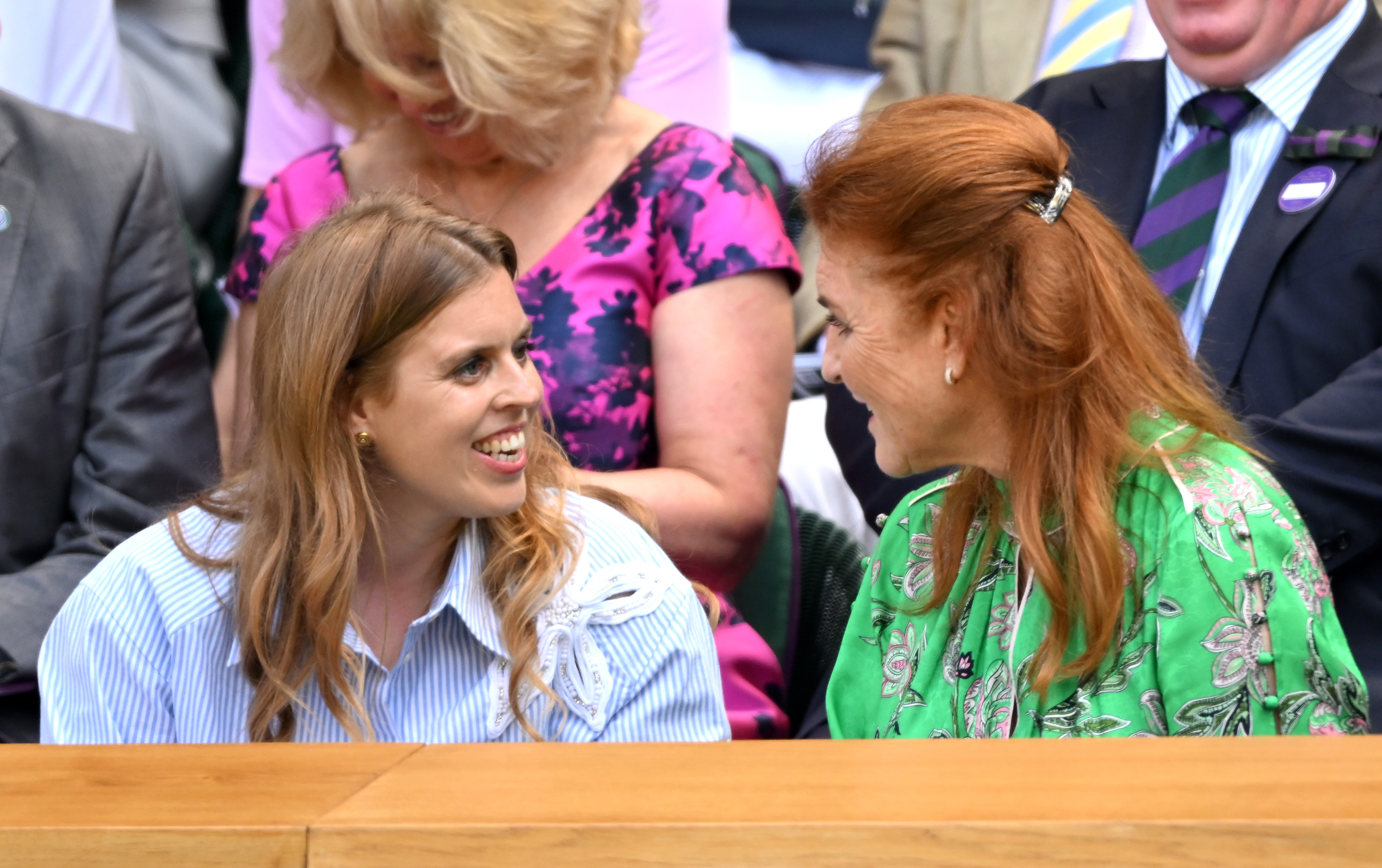 Princess Beatrice and Sarah Ferguson smiling at each other sitting at Wimbledon 2025