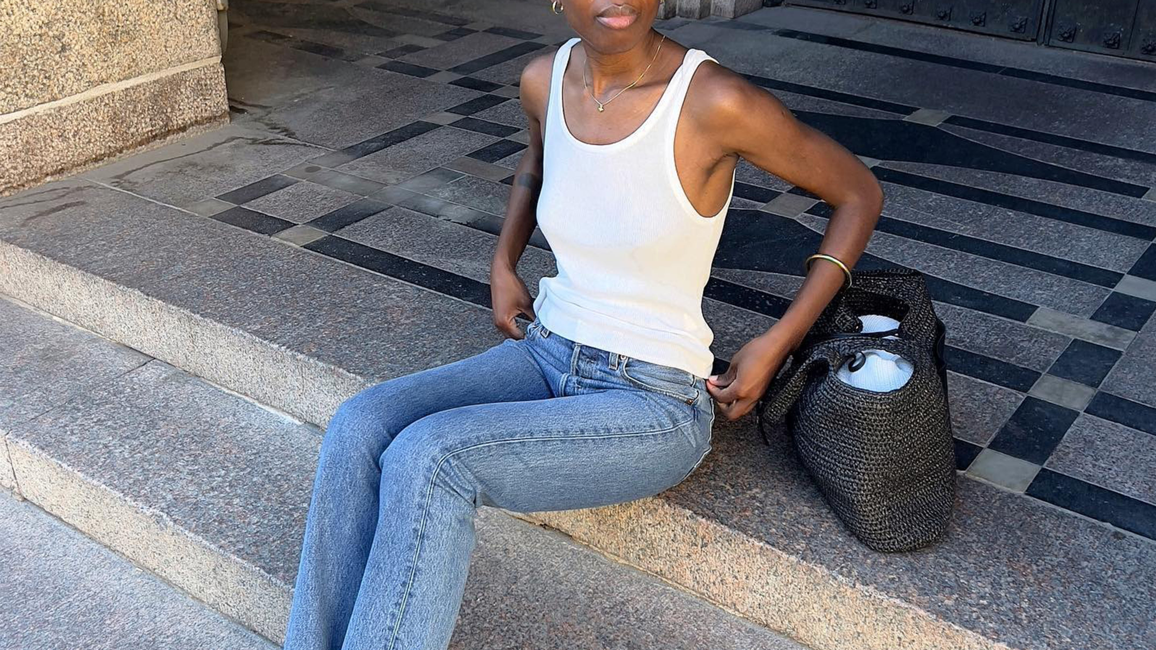 Woman in a white tank top and jeans