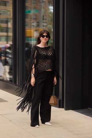 a street style image of Kat Collings wearing a black crochet Diotima top with Zara trousers and Agmes silver cuff bracelets