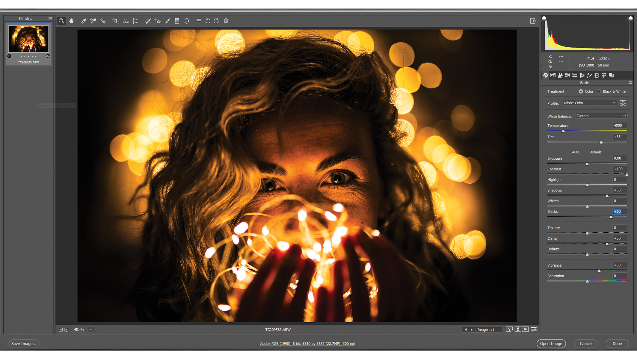 A Photoshop window with editing menus, an image in the center showing a person with wavy hair surrounded by soft, golden bokeh lights that create a warm and dreamy atmosphere