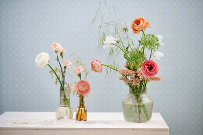 A selection of pink cut flowers in three glass vases