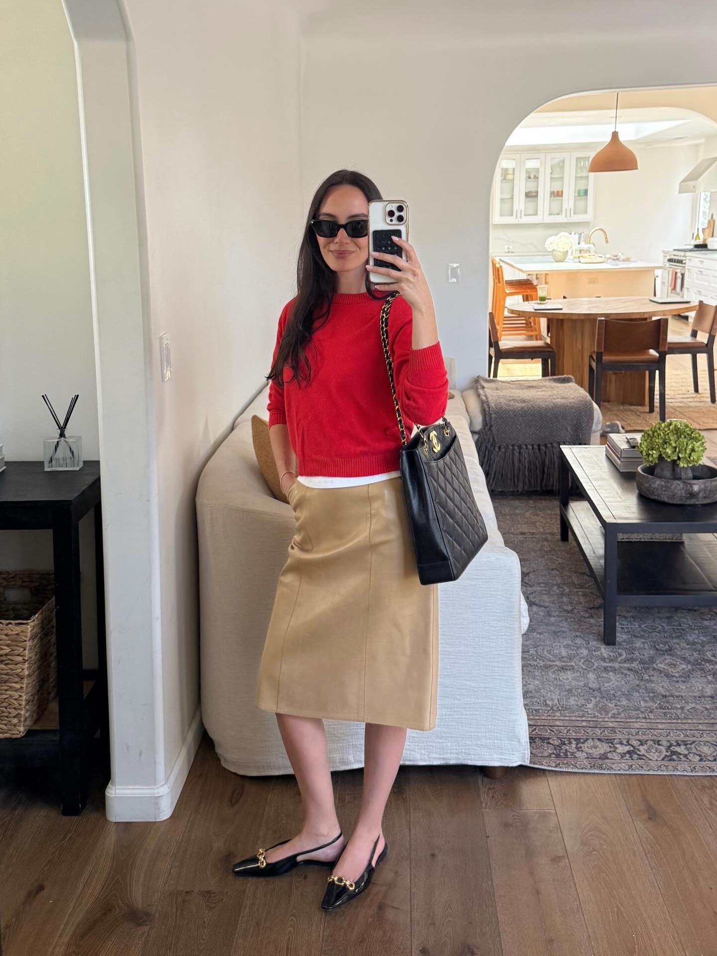 Influencer Liv Perez wearing a red sweater and khaki knee skirt.