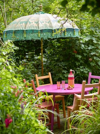 orange and pink painted dining set with a colourful parasol