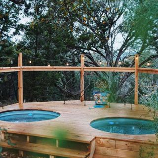 Two above-ground swimming pools with decking around it