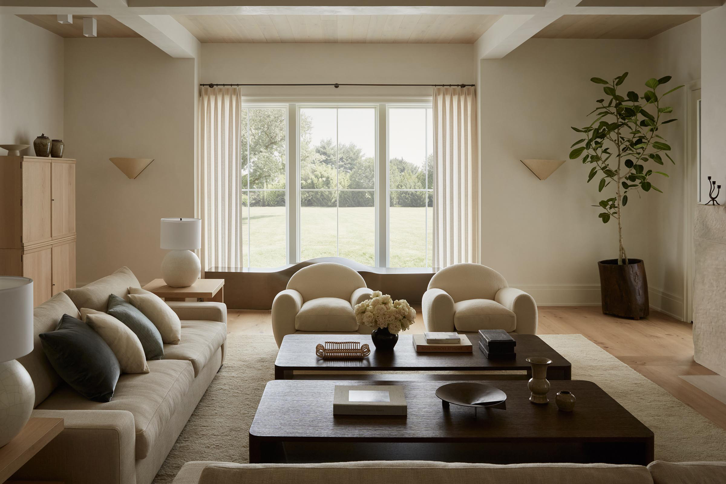 A contemporary living room in a soft contrast palette of white, gray, cream, linen, velvet, and wood colors and materials