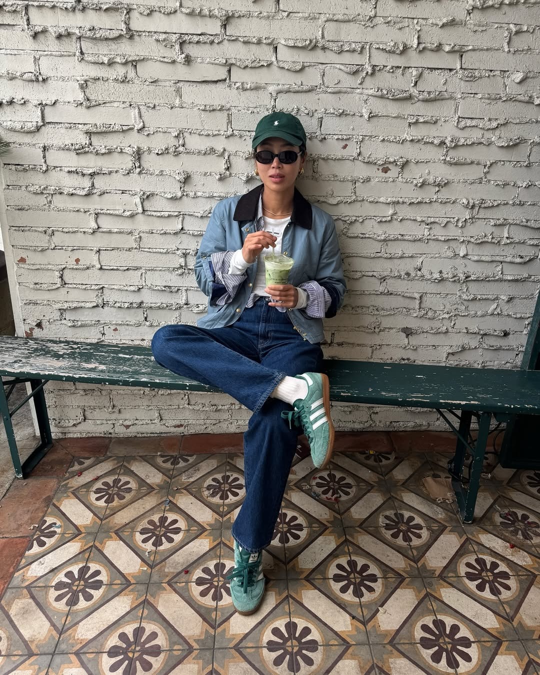 @aimeesong wearing Adidas sneakers, jeans, barn coat, hat, and white shirt