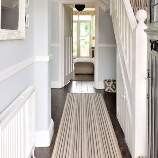 white hallway and stairwell with a striped runner
