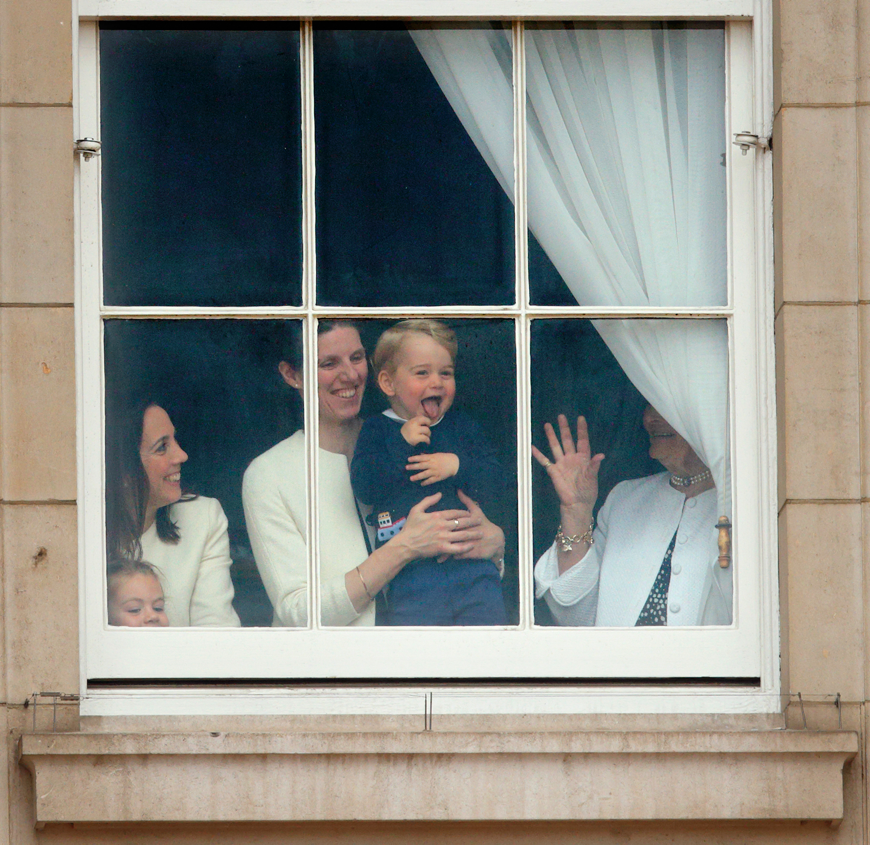 Nanny Maria holding Prince George up to a window and laughing
