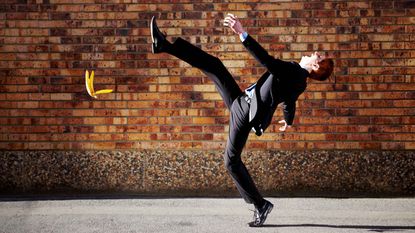 A businessman slips on a banana peel