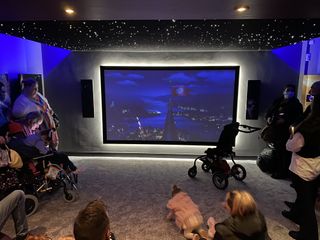 A starry sky is displayed on a projection screen at a Snap One-crafted theater at a children's hospice.