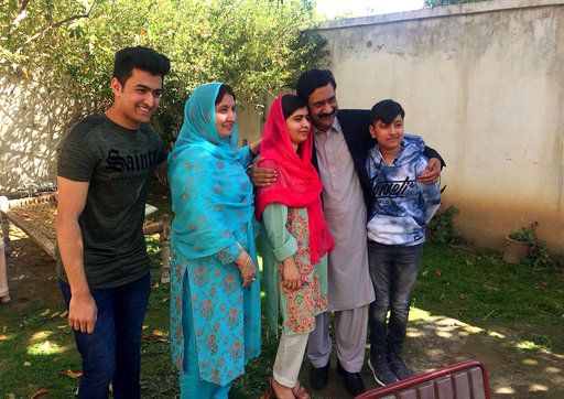 Pakistan&amp;#039;s Nobel Peace Prize winner Malala Yousafzai, center, poses for a photograph with her family members at her native home during a visit to Mingora, the main town of Pakistan Swat Valle