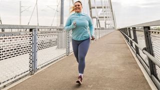 Woman running along footpath over bridge