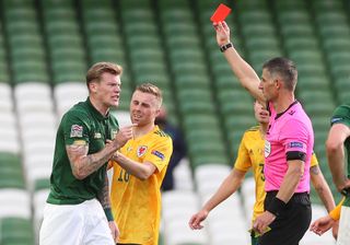Referee Anastasios Sidiropoulos (right) shows a red card to Republic of Ireland midfielder James McClean against Wales
