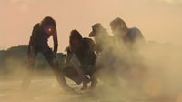 Members of Pink Floyd crouching down wreathed in smoke at Pompeii.