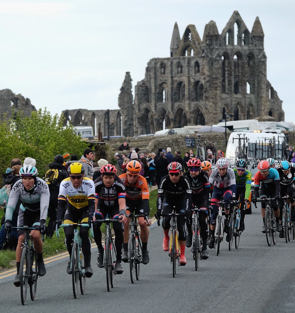 Riders competing in stage three of the Tour de Yorkshire cycle race ride past Whitby Abbey on May 1, 2016 in Whitby, England.
