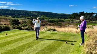 Carly Cummins tees off wearing headphones