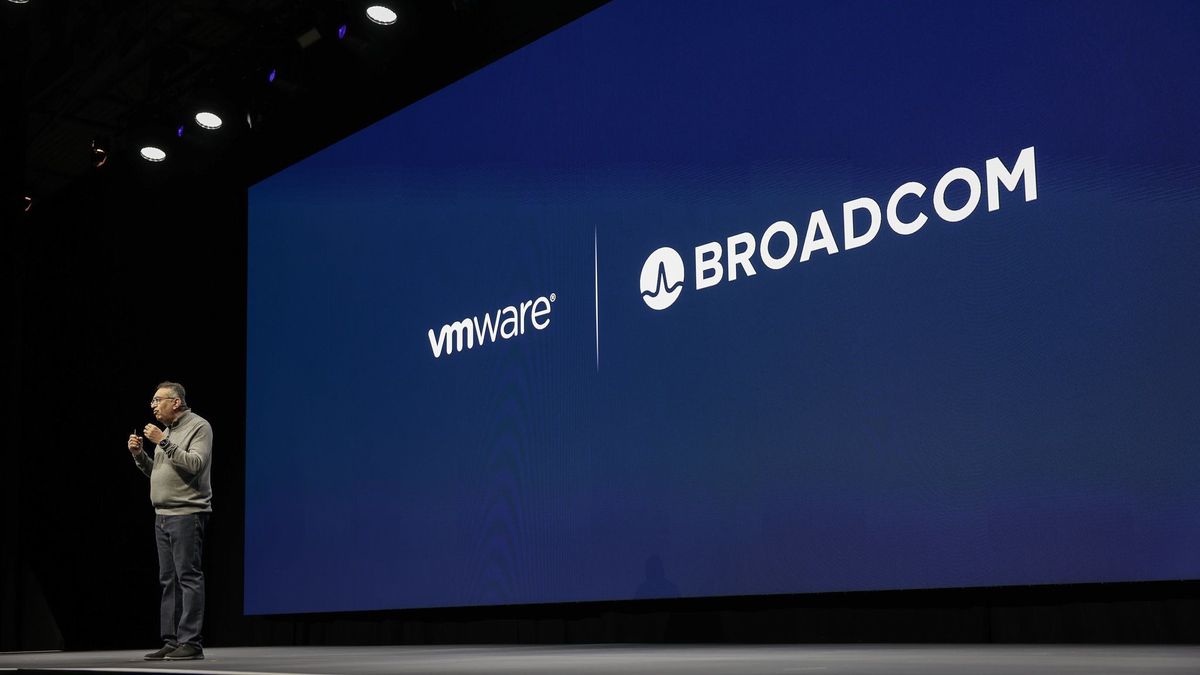 VMware CEO Raghu Raghuram, standing on the keynote stage in front of a screen bearing the VMware and Broacom logos