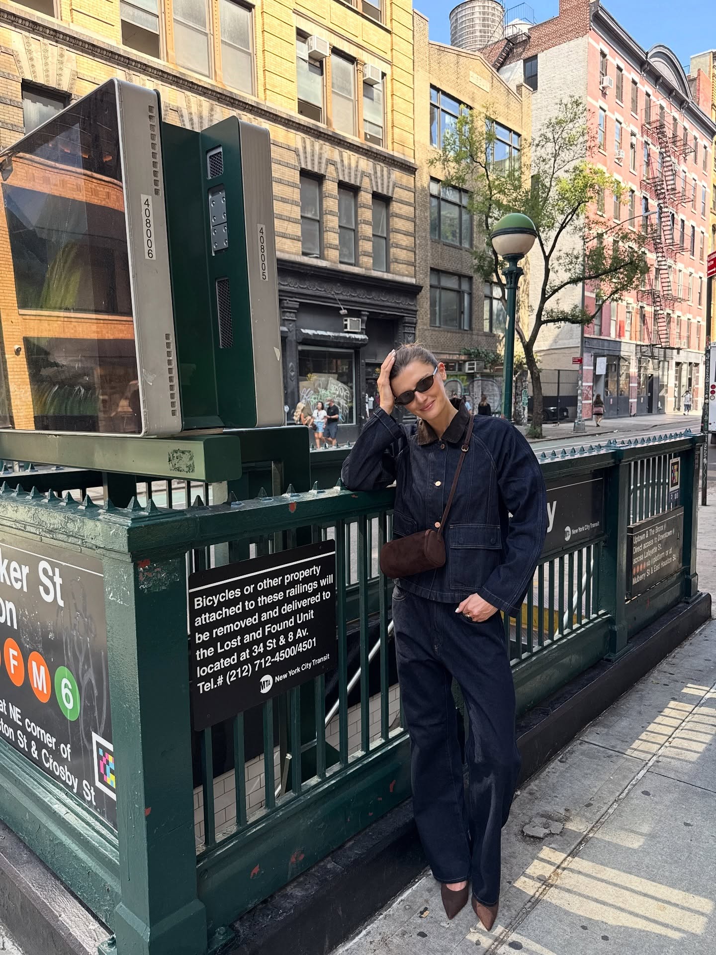 Influencer @cocoschiffer wears a denim two-piece with brown satin heels and a brown suede cross-body bag.