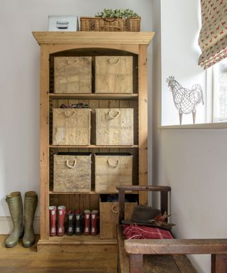 A hallway shoe storage idea with freestanding wooden shelves with basket inserts