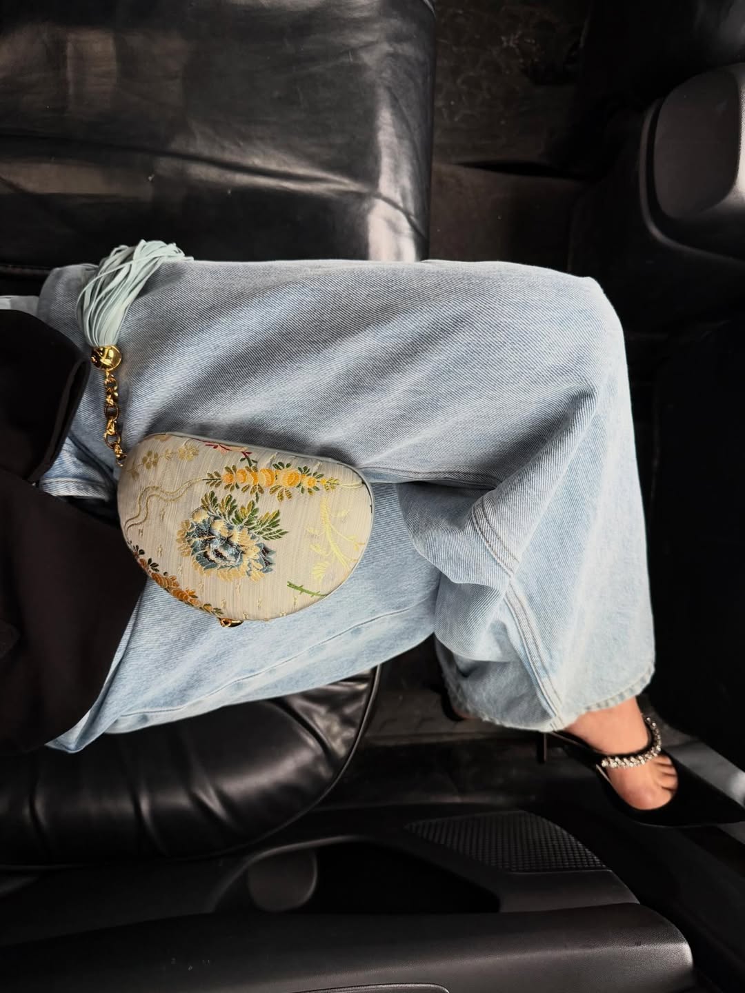 a detail image of an embroidered tassel clutch