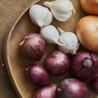 onions and garlic on wooden plate