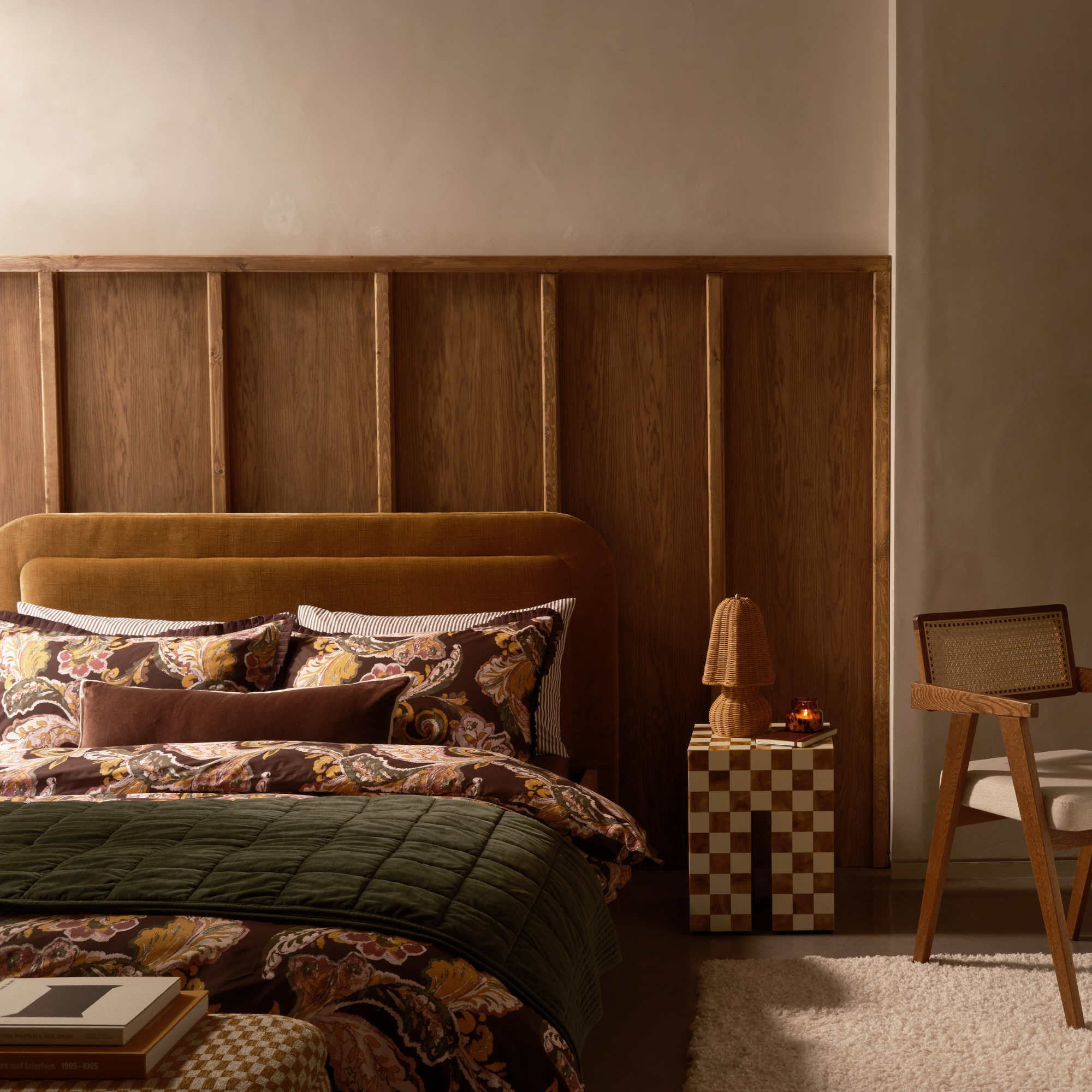 Cosy bedroom with wicker lamp on bedside table.