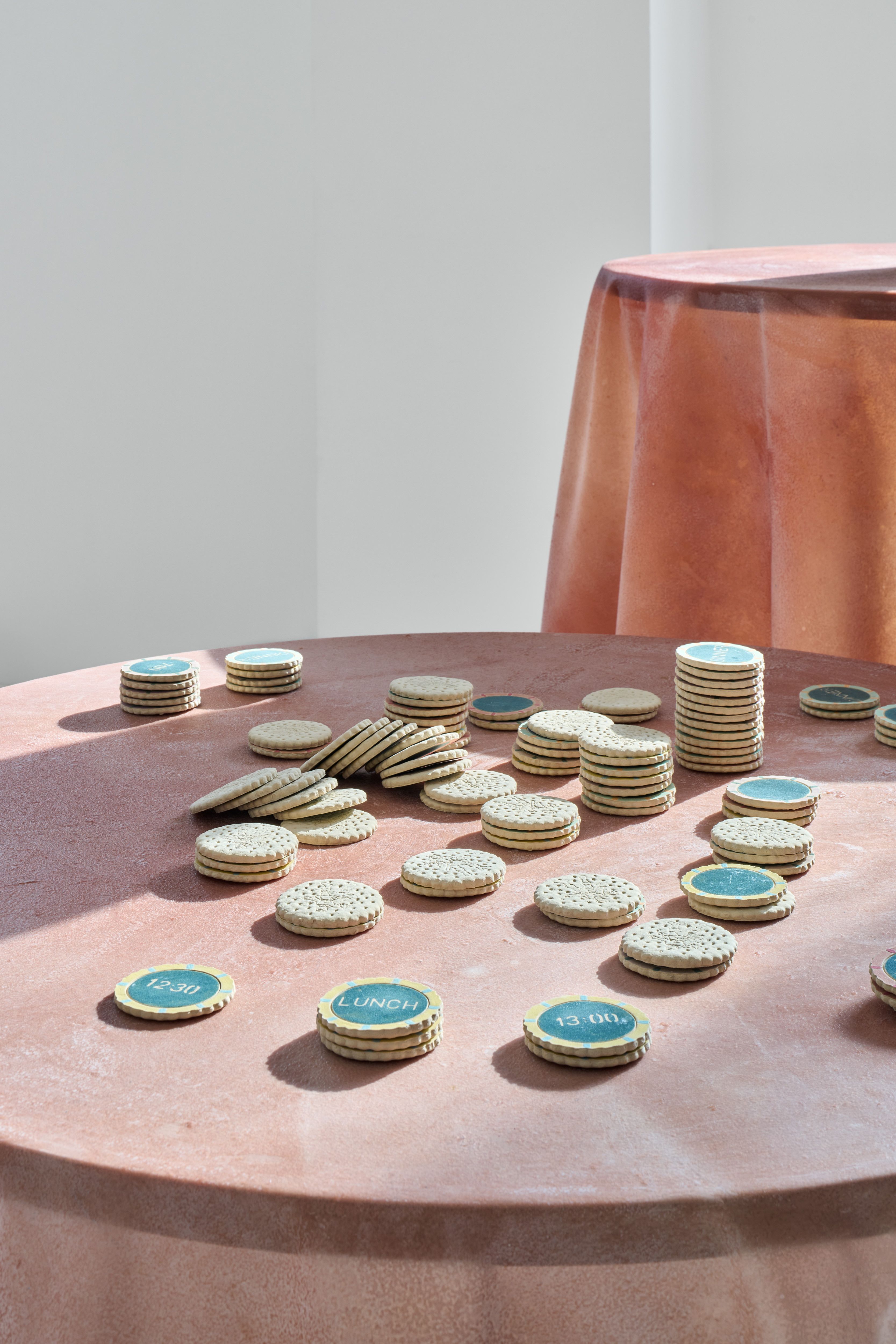 Installation shots of a series of exhibitions showcasing quirky ceramics and dreamy paintings in a colorful, pastel-tinted setting.