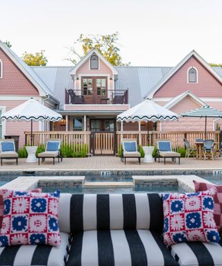 pink house with a pool and striped sofa