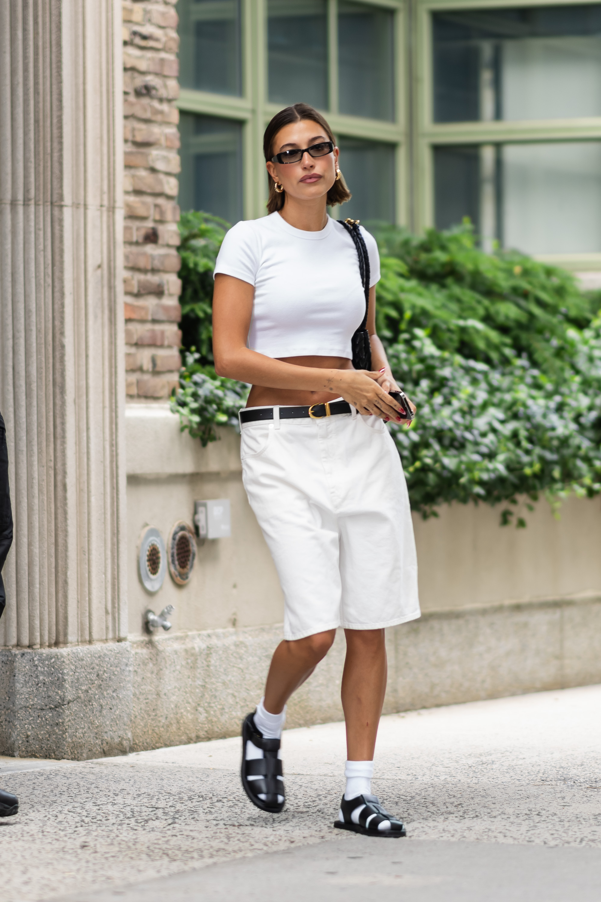 Hailey Bieber in white bermuda shorts and fisherman sandals