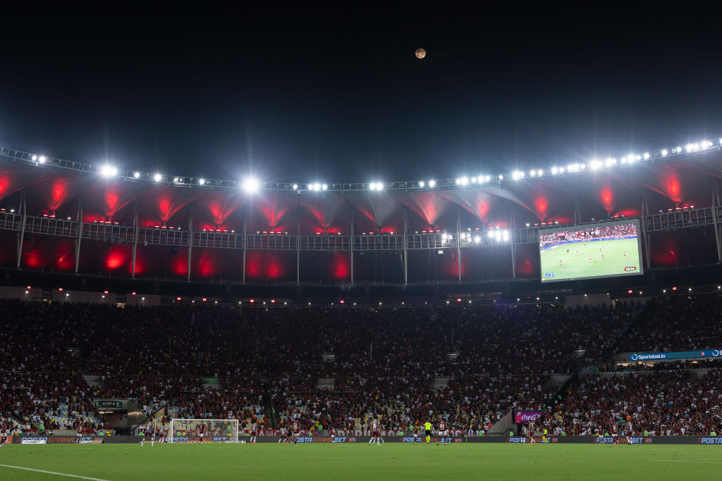 Une petite sphère orange au-dessus d’un stade de football courbé