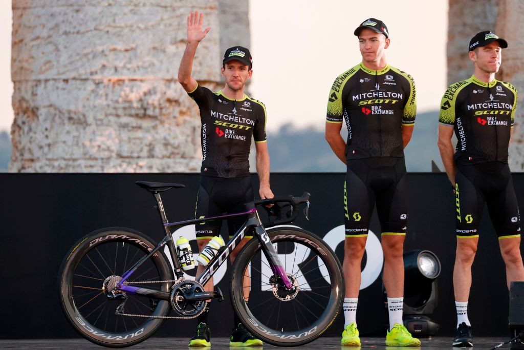 Team Mitchelton rider Great Britains Simon Yates L waves on stage at the Doric Temple of Segesta near Palermo Sicily on October 1 2020 during an opening ceremony of presentation of participating teams and riders two days ahead of the departure of the Giro dItalia 2020 cycling race Photo by Luca Bettini AFP Photo by LUCA BETTINIAFP via Getty Images