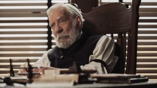 Donald Sutherland as Judge Parker sitting behind a table.