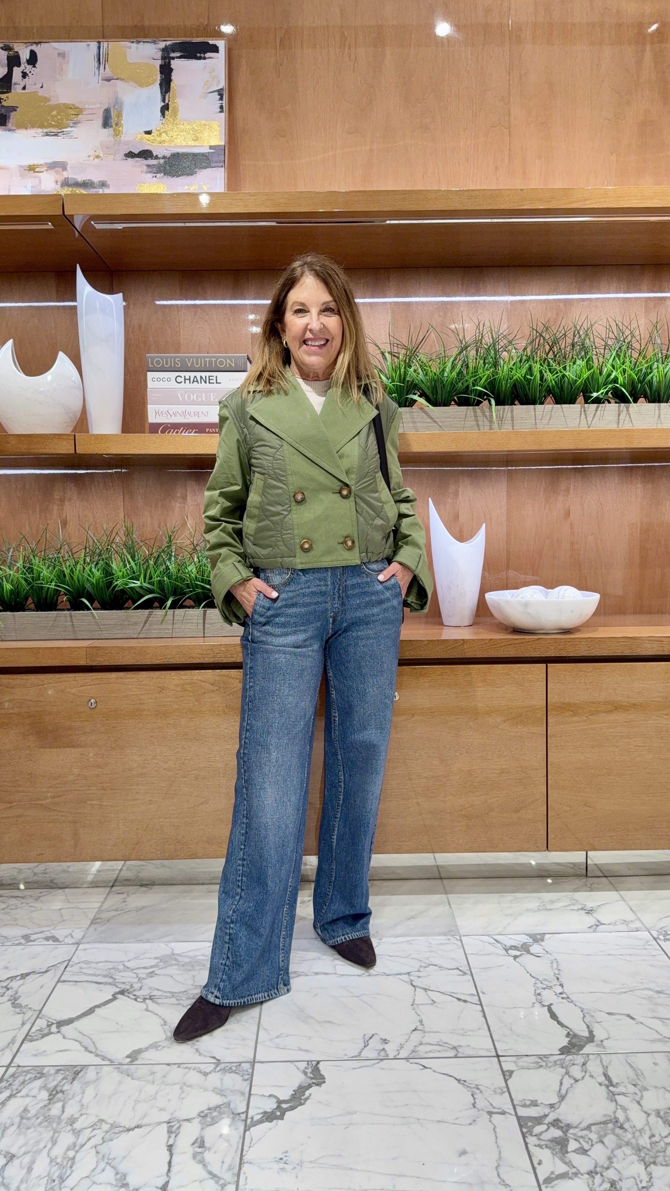 Sandy Koszarek wearing a green jacket and jeans.