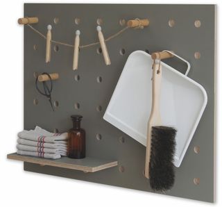 a peg board storing cleaning and laundry materials such as detergent and a brush