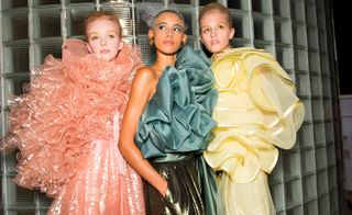 Models wear ruffled dresses in pink, green and yellow