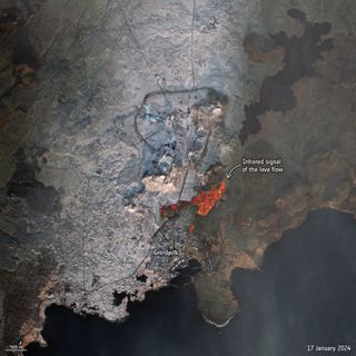 bright red magma can be seen in an overhead photo of a coastal town