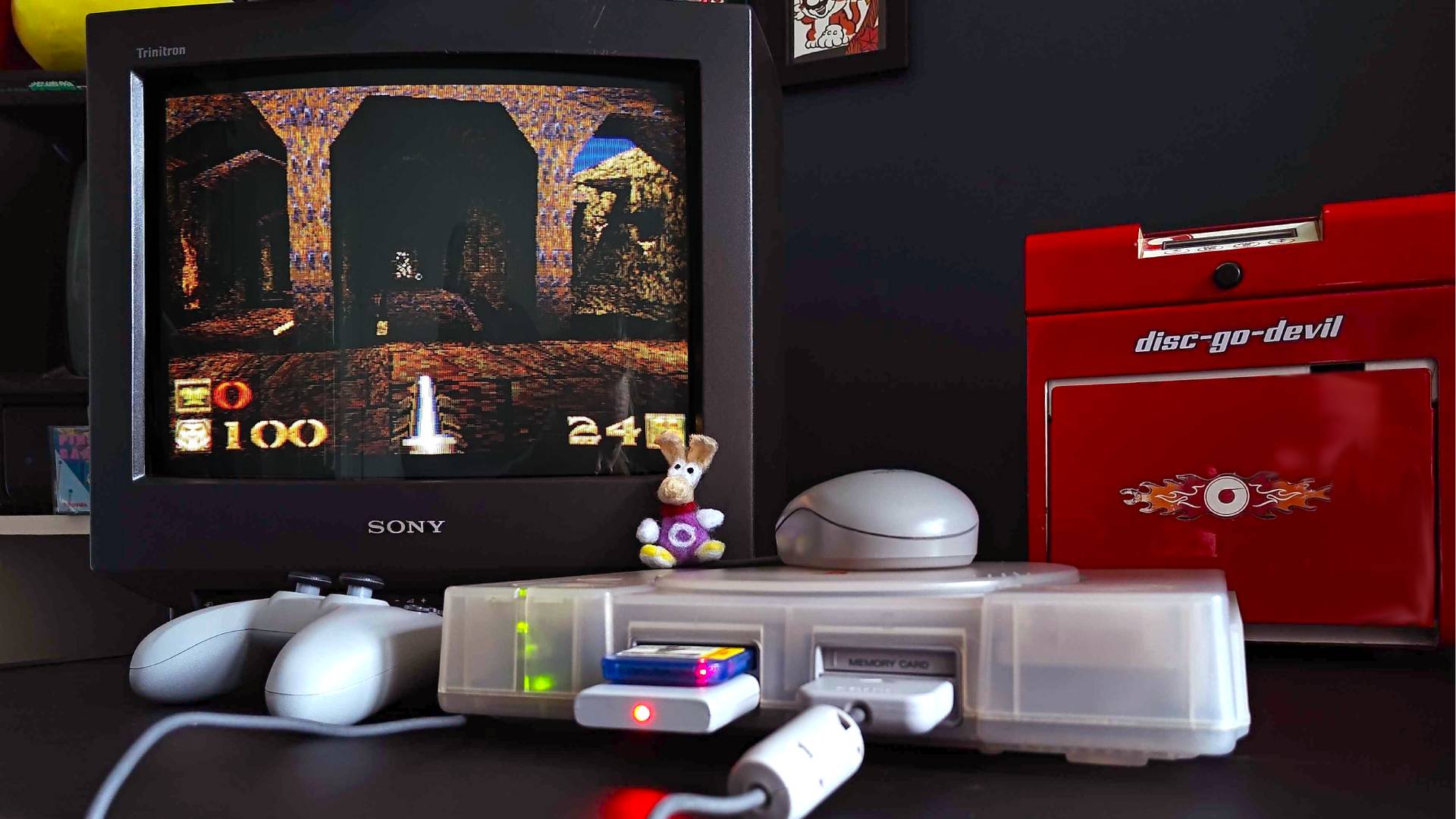 PS1 with transparent shell connected to Sony Trinitron CRT TV with Quake gameplay on screen.