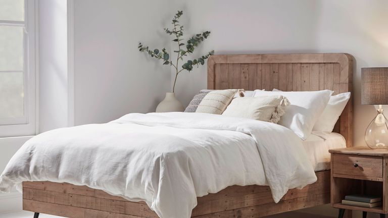 double bed with wooden frame and fresh white bedding 