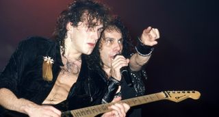 Vivian Campbell and Ronnie James Dio onstage in 1985 as they tour Campbell's final studio album with Dio, Sacred Heart. Campbell is playing a well-worn Charvel S-style electric guitar.