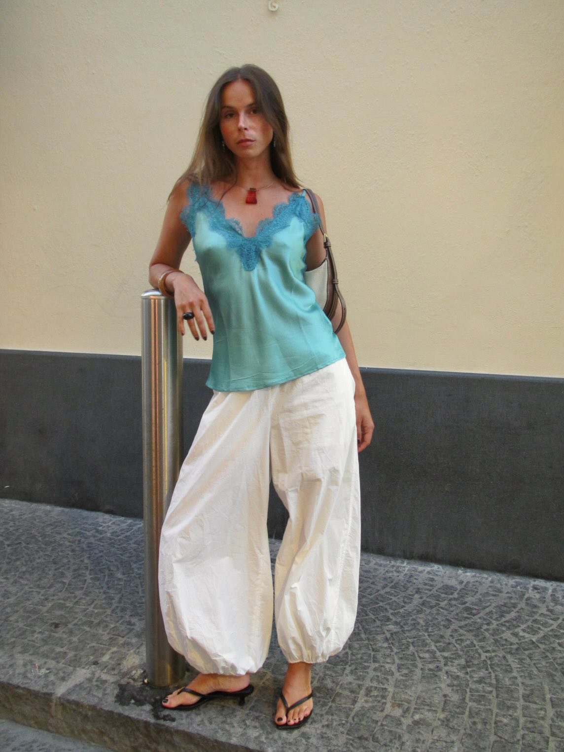 Influencer Johanna lager wearing a turquoise lace camisole, sarouel trousers and heeled thong sandals.