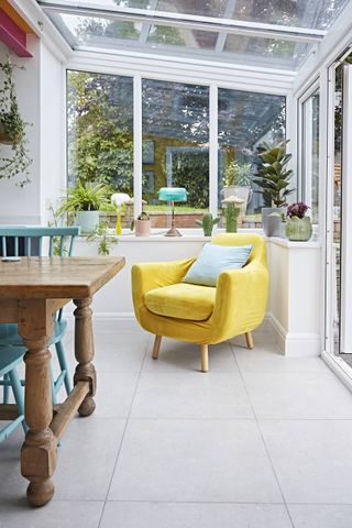 small modern conservatory with yellow chair in dining room