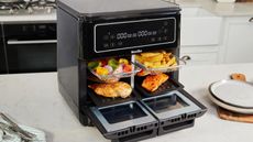 Breville Halo Flexi Air Fryer on he countertop with four trays in with different foods on them