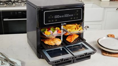 Breville Halo Flexi Air Fryer on the countertop with four trays in with different foods on them