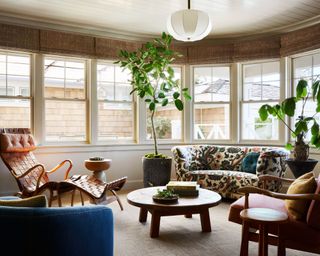 living room with neutral walls, bay windows and cozy seating area