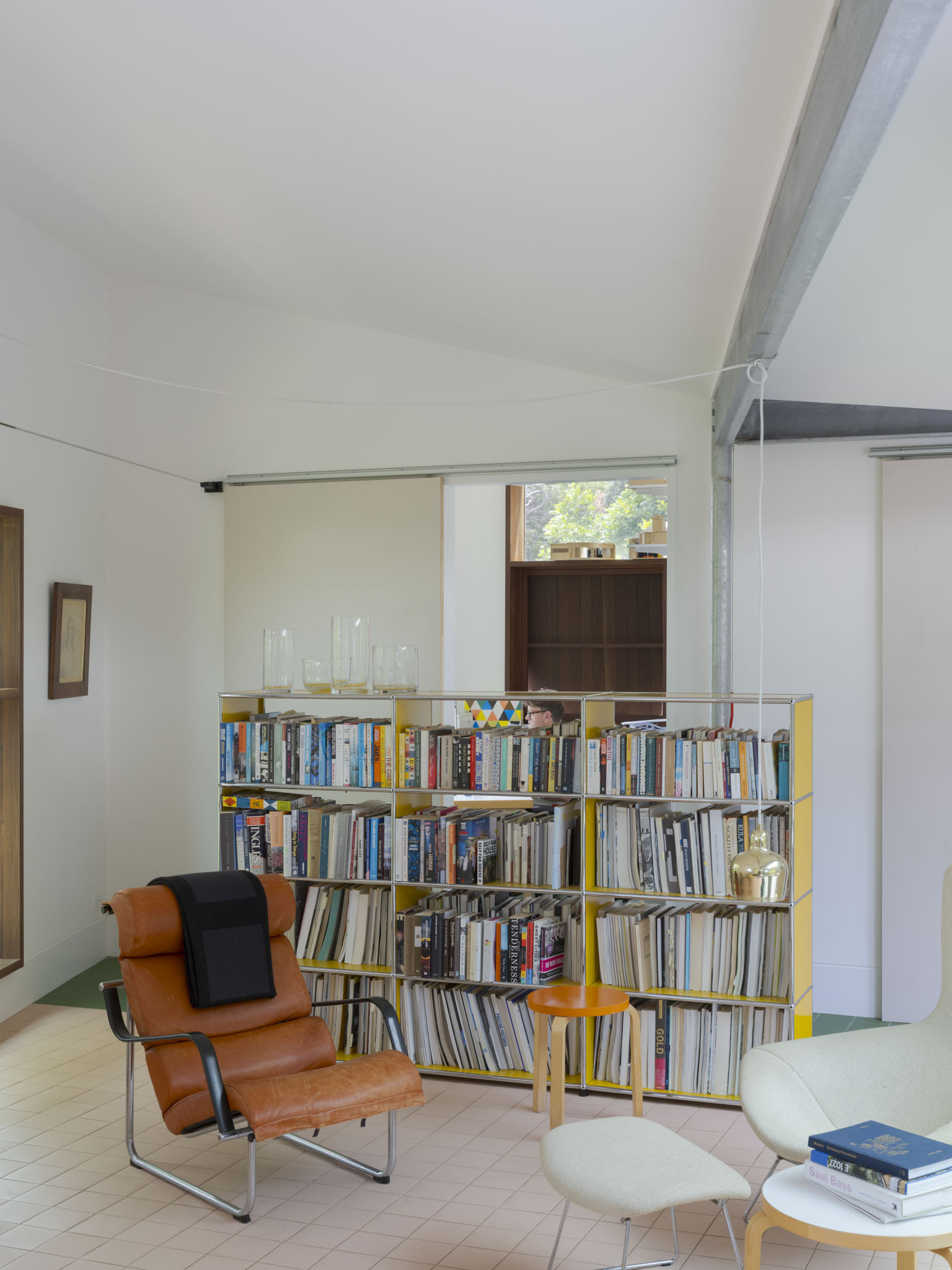 a white boxy house, scarborough house in australia, among wooded setting and with colourful furniture