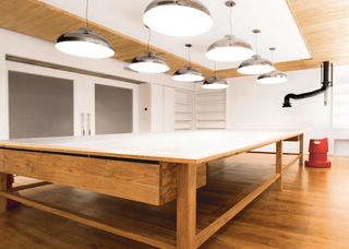 Large wooden table with light fittings above