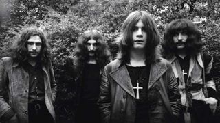 Black Sabbath standing in front of some bushes