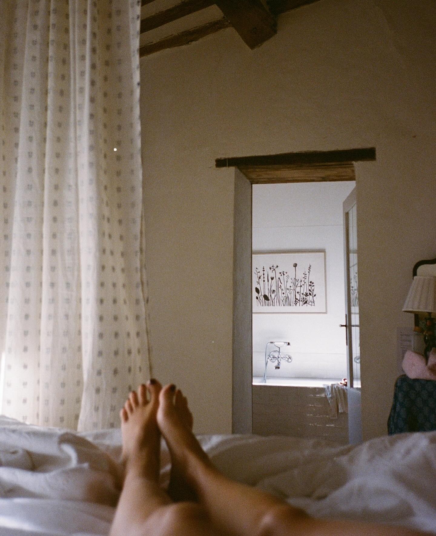A woman taking a picture of her legs on a hotel bed