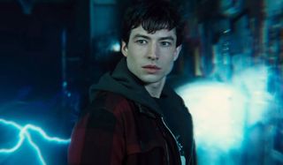 Ezra Miller staring straight ahead with lightning behind him.